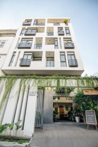 a large white building with plants on the facade at Sen Boutique House By 5H in Ho Chi Minh City