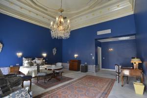 Dormitorio azul con cama y lámpara de araña en Palais Bayram en Túnez