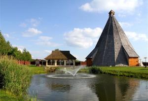 a fountain in a pond in front of a building at Vigvam penzion in Němčice