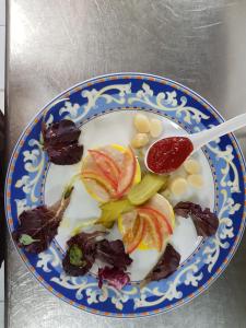 a blue and white plate of food with fruit and a spoon at Aparta-Hotel Puertolas in Escuer