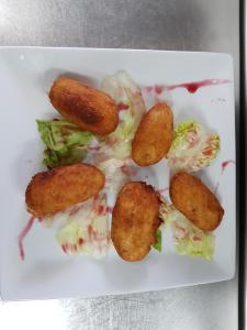un plato de comida con ensalada y comida frita en Aparta-Hotel Puertolas en Escuer