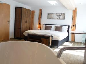 a bedroom with a bed and a bath tub at Hotel Restaurant Knobelboden in Oberterzen