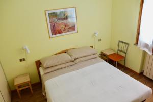 een slaapkamer met een wit bed in een kamer bij Appartamento Holiday Rimini 100mt dal mare in Rimini