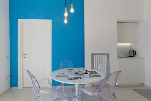 a dining room with a white table and chairs at Relais Mareluna - Luxury Apartments in Salerno
