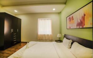 a bedroom with a white bed and a window at Eternal wave by HappyInch in Calangute