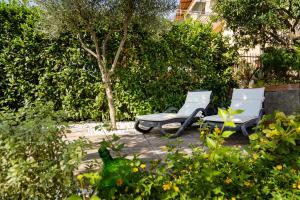 duas cadeiras brancas e uma mesa num jardim em Villa Russo em Vico Equense