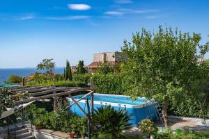 una piscina en un jardín con árboles y plantas en Villa Russo en Vico Equense
