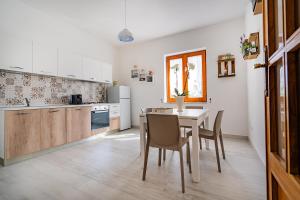 uma cozinha com mesa e cadeiras num quarto em Villa Russo em Vico Equense