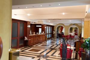 un vestíbulo con sillas rojas y un salón en Villa Venus Resort & SPA, en Atena Lucana