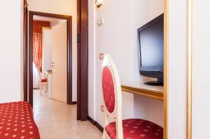 a living room with a tv and a chair at Hotel King in Rimini