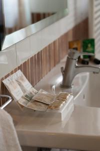 a bathroom sink with a faucet with pamphlets on it at Hotel Villa Venus Resort & SPA in Atena Lucana