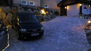 a car parked in front of a stone wall at Ferienwohnung am Silberg in Plettenberg