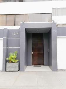 un bâtiment avec une porte et une usine de pot dans l'établissement Departamento Monterrico, à Lima