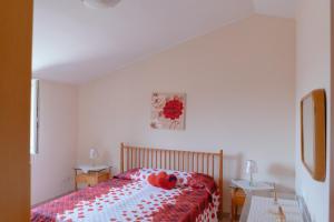 een slaapkamer met een bed met rode teddyberen erop bij Le Ginestre in Miglionico