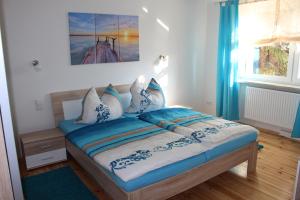 um quarto com uma cama com almofadas azuis e brancas em Villa LE em Leipzig