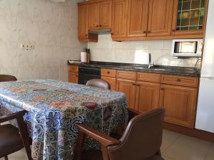 uma cozinha com uma mesa com cadeiras e um frigorífico em Casa Rural Casa Juli em Arguedas