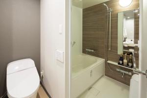 a bathroom with a toilet and a tub and a shower at Shizutetsu Hotel Prezio Hakataekimae in Fukuoka