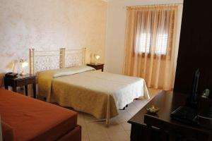 a hotel room with a bed and a window at Abbadia in San Vito lo Capo