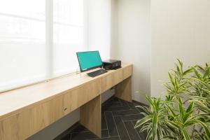 a laptop computer sitting on a desk next to a window at Shizutetsu Hotel Prezio Hakataekimae in Fukuoka