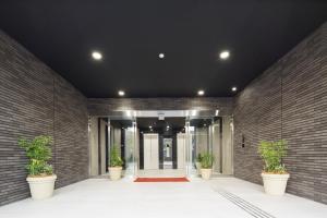 a hallway with potted plants in front of a building at Shizutetsu Hotel Prezio Hakataekimae in Fukuoka