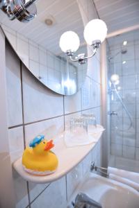 um pato de borracha sentado numa prateleira na casa de banho em Hotel Hecht Garni em Ingolstadt