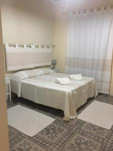 1 dormitorio con 2 camas y toallas. en Guest House Le Gemelle, en Luras