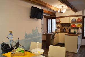 cocina con mesa y TV en la pared en CA' DE' KOCAI, en Venecia