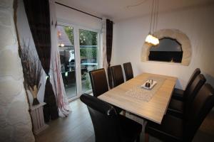 a dining room with a wooden table and chairs at Haus Abbi, Ferienwohnung mit Schwimmbad in Hage