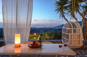 Glinado Naxos的住宿－Naxos Villa Bella Vista，一张桌子,上面放着两杯葡萄酒和蜡烛
