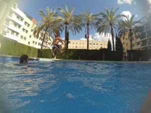 a man jumping into a swimming pool with a basketball at Habitación doble con baño privado, Desayuno y piscina in Alboraya