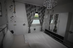 a bedroom with a bed and a window at Haus Abbi, Ferienwohnung mit Schwimmbad in Hage +23 photos