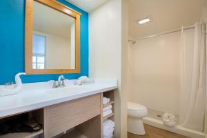 a bathroom with a sink and a toilet and a mirror at Outrigger Beach Resort in Fort Myers Beach