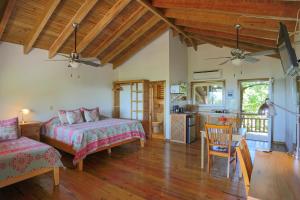 una camera con due letti e una cucina con tavolo di Hotel Posada Seremein ,West Bay ,Roatan a West Bay