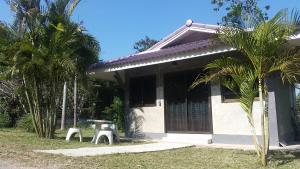 a small house with two benches in front of it at บ้านสวนวงศ์จินดารักษ์ in Phayao