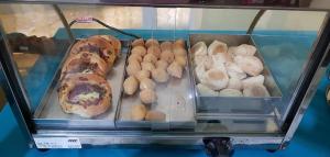 a display case filled with different types of donuts at Lisboa Palace Hotel in Alta Floresta
