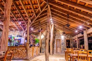 una sala da pranzo con soffitti in legno e tavoli e sedie in legno di Hotel Posada Seremein ,West Bay ,Roatan a West Bay