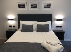 una camera da letto con un grande letto bianco con due comodini di The Studio Akaroa ad Akaroa