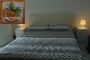 a bed in a bedroom with two nightstands and two lamps at Galatea in Mascali