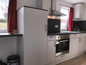 a kitchen with white cabinets and a stove top oven at Fiala Home in Neumünster
