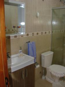 a bathroom with a sink and a toilet and a mirror at Recanto na Montanha de Gramado in Gramado
