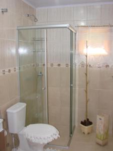a bathroom with a toilet and a glass shower at Recanto na Montanha de Gramado in Gramado +74 photos