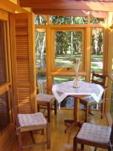 a porch with a table and chairs and a window at Recanto na Montanha de Gramado in Gramado