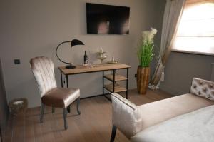 sala de estar con escritorio, silla y sofá en B&B Serenity en Neerpelt