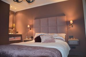 1 dormitorio con 1 cama grande y cabecero grande en B&B Serenity en Neerpelt