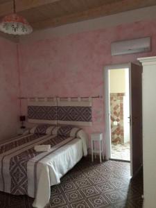 a bedroom with two beds and a pink wall at Guest House Le Gemelle in Luras