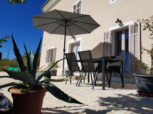 a patio with a table and chairs and an umbrella at Vila Flora in Sečovlje