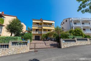 a building with a stone fence in front of a street at Apartman Laura in Selce