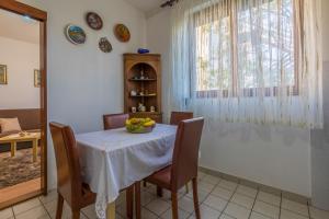 a dining room with a table with a bowl of fruit on it at Apartman Laura in Selce +16 photos