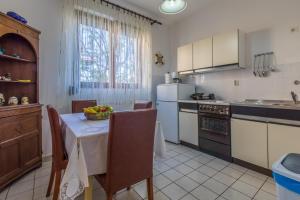 a kitchen with a table with a bowl of fruit on it at Apartman Laura in Selce