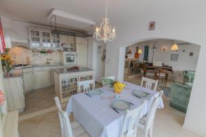 eine Küche und ein Esszimmer mit einem weißen Tisch und Stühlen in der Unterkunft Eco Eclectic Villa with pool in Solin